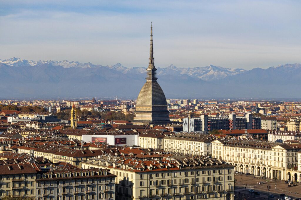 Discover the stunning cityscape of Turin with the iconic Mole Antonelliana and the Alps in the background.